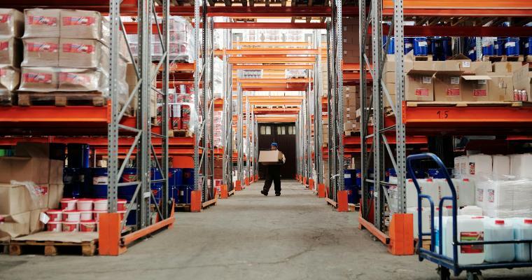 Employee carrying a box through a warehouse