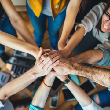 Photo of hands in, where people form a circle and put their hands in