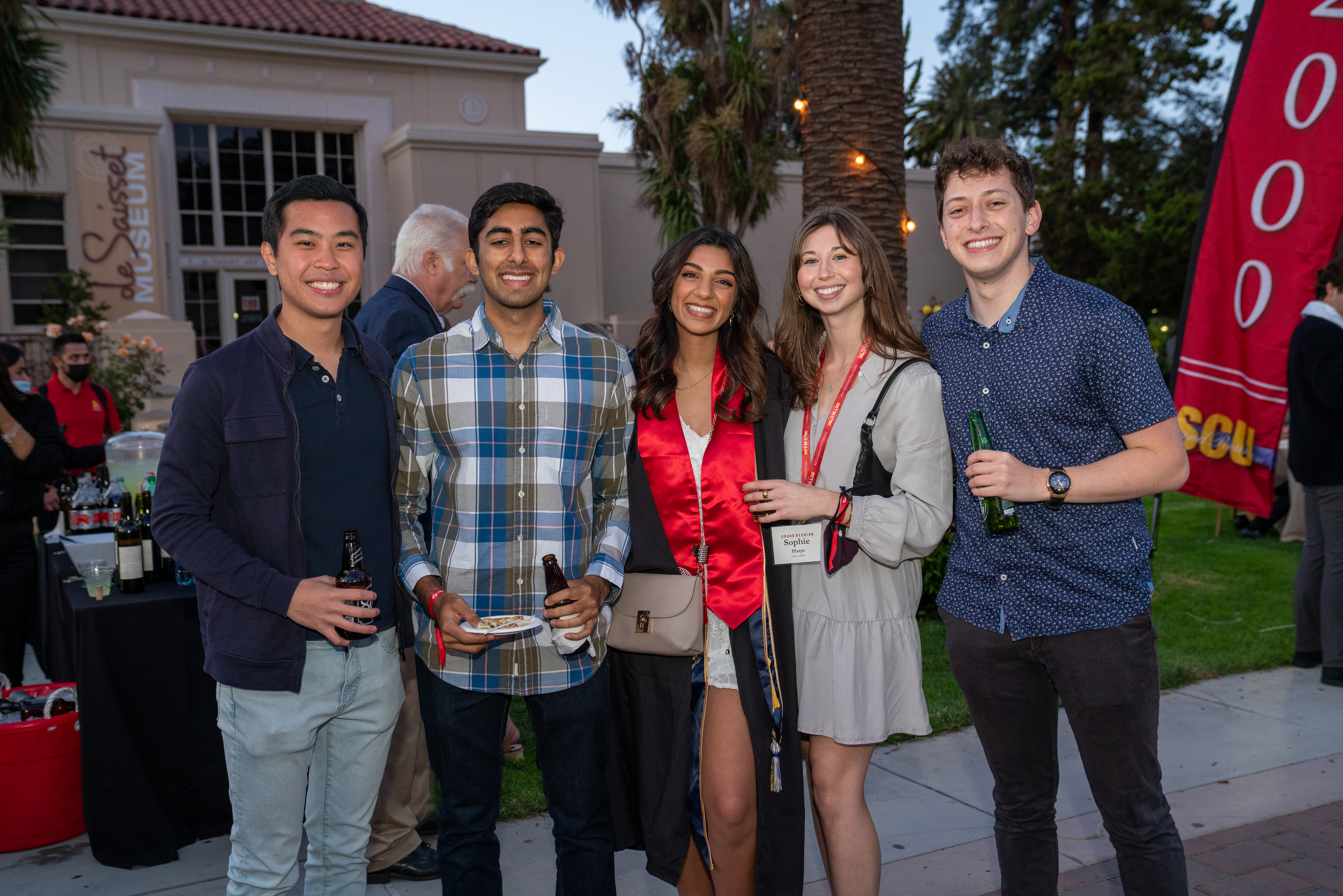 Five alumni stand together and smile at the camera during a Class of 2020 event