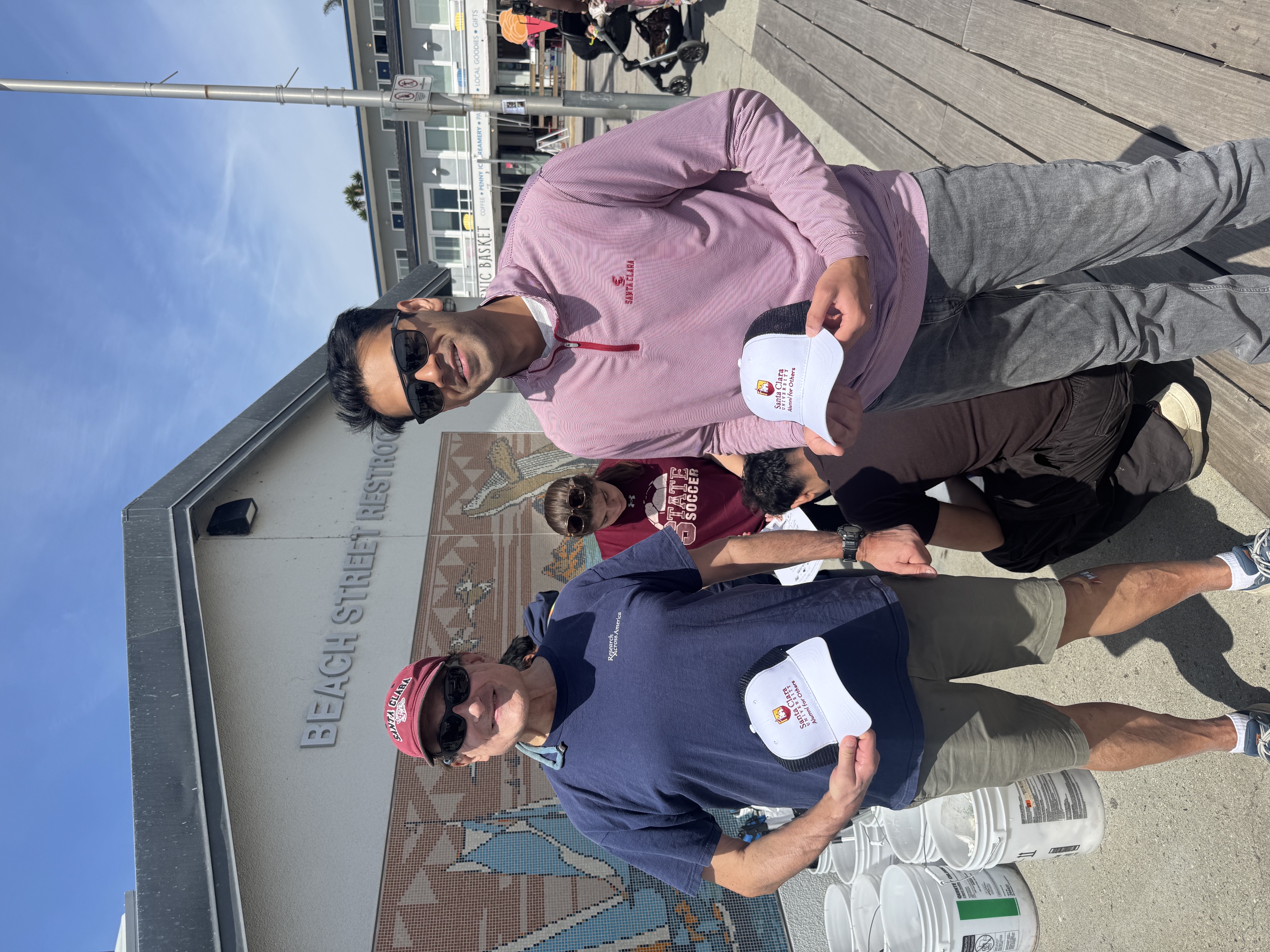 Alumni smiling with their new hats