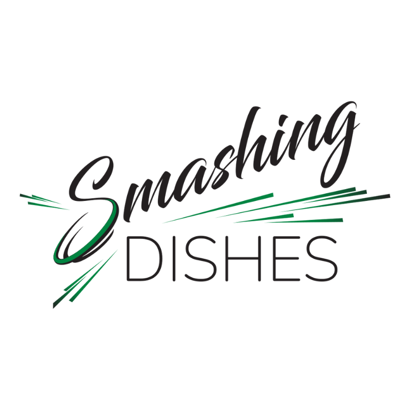 The word Smashing tilts upwards in cursive font above the word Dishes. Green flares and accents surround the words to give a smashing effect 