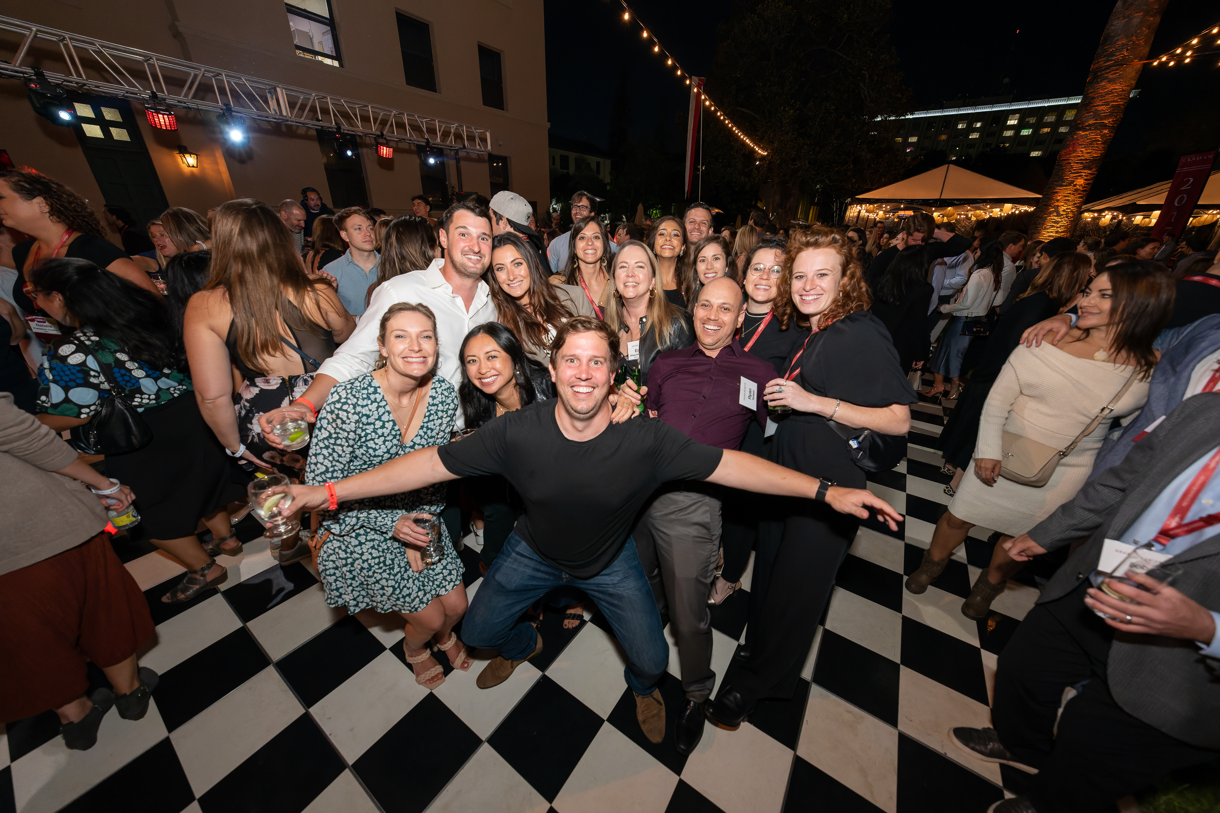 Group of alumni posing for photo on dance floor 