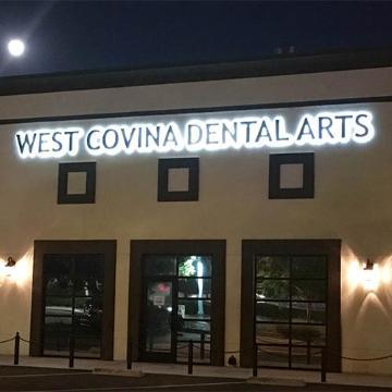 David W. Alfaro DDS signage on building facade at night.