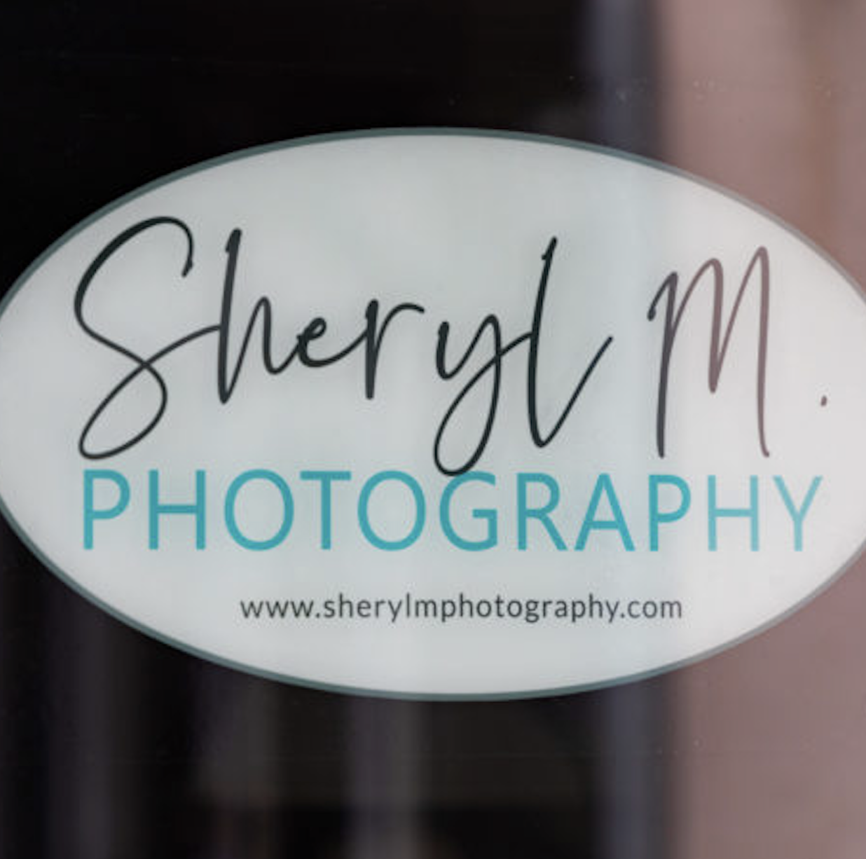 Sheryl M Photography logo with tagline 'a visual expressionist' in a white oval.