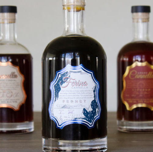 Three bottles of liquor from Ferino Distillery with detailed labels.