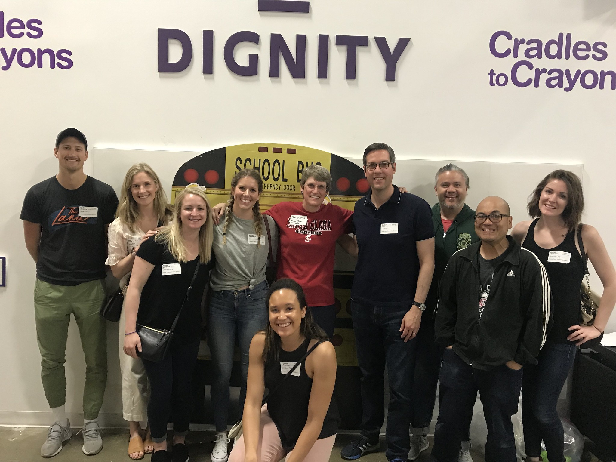 Chicago Alumni in front of a wall with a school bus decoration
