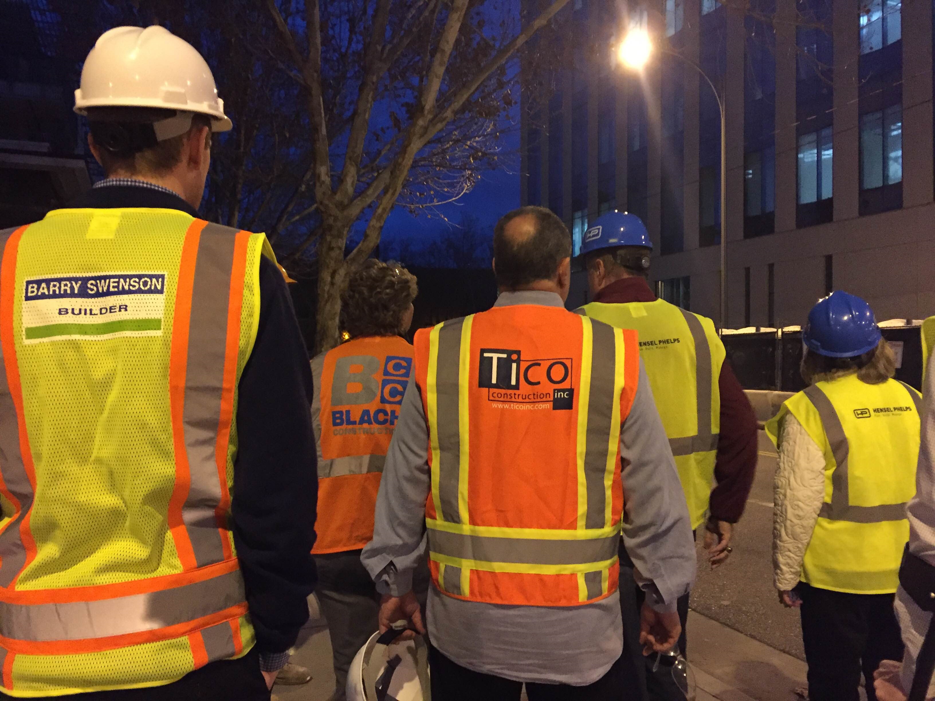 Construction workers in safety gear at night with Transtek Traffic Solutions labeled on a vest.