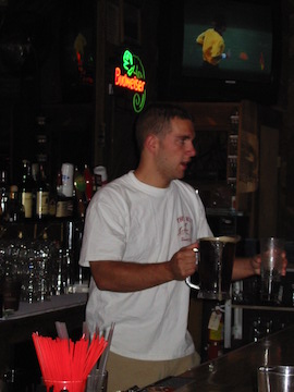 A person holding a drink at a bar.