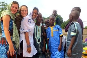 Group of people smiling together, some wearing medical coats and stethoscopes.