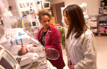 Two professionals working with medical equipment in a healthcare facility.