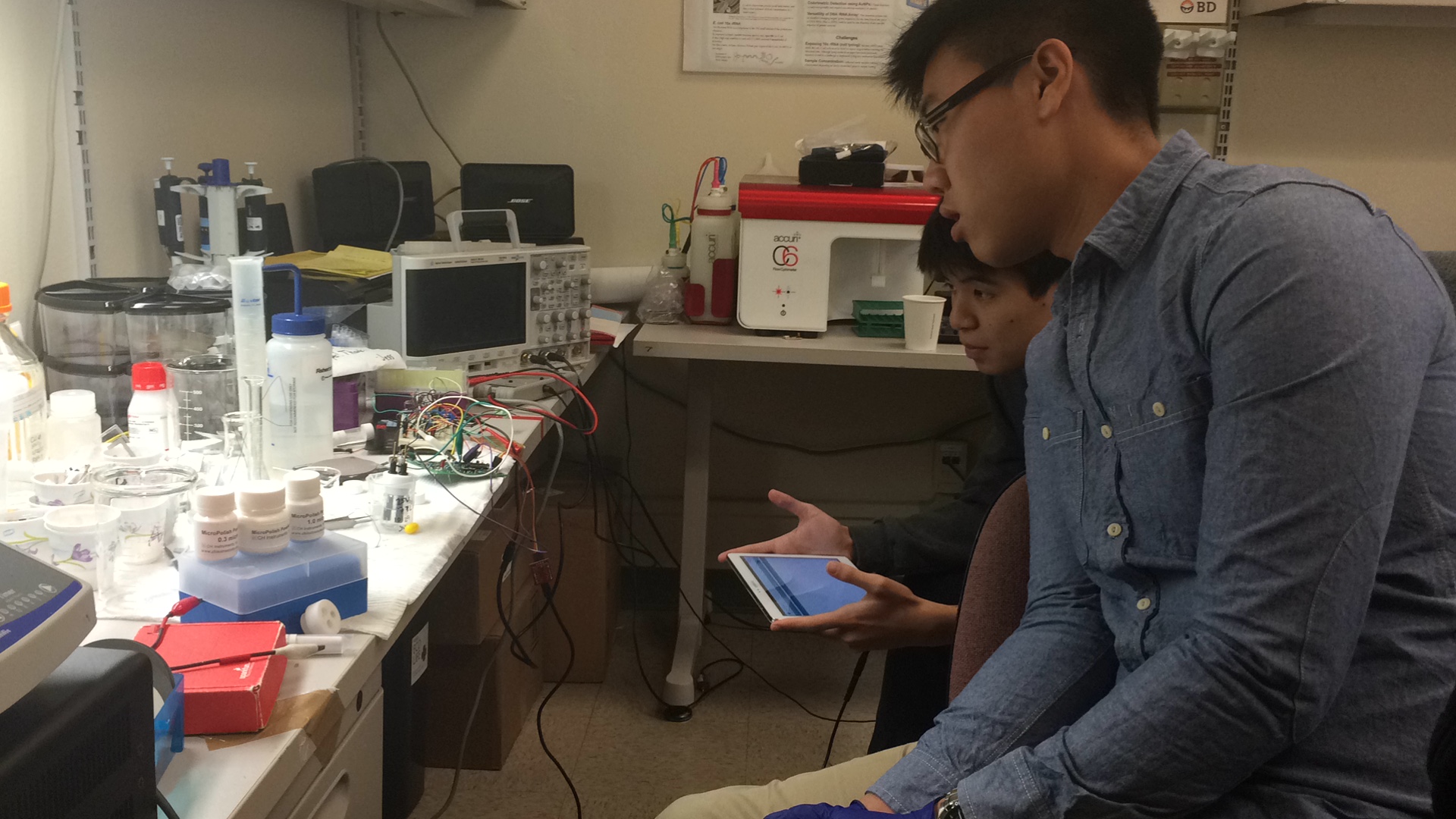 Two people working in a lab with various equipment. image link to story