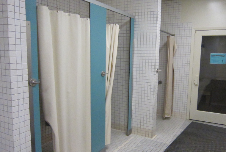 Locker room with shower stalls and curtains.