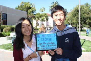 Two people holding a sign reading Today I pledge to choose love.