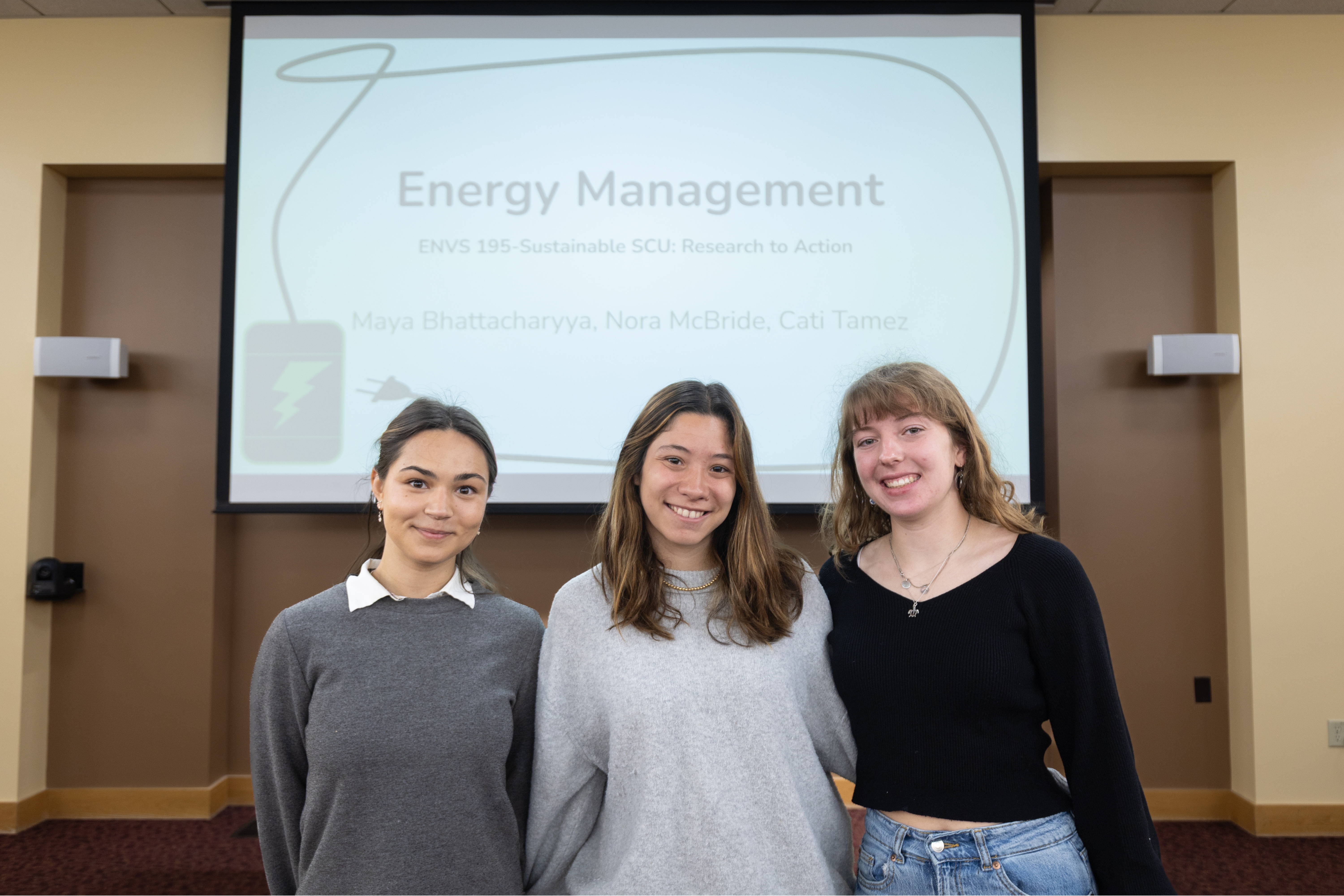 Three students stand in front of their Energy Management presentation for the 2025 Sustainability and EJ Symposium.