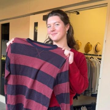 A student holds up a plaid shirt in from of Bucky's Closet