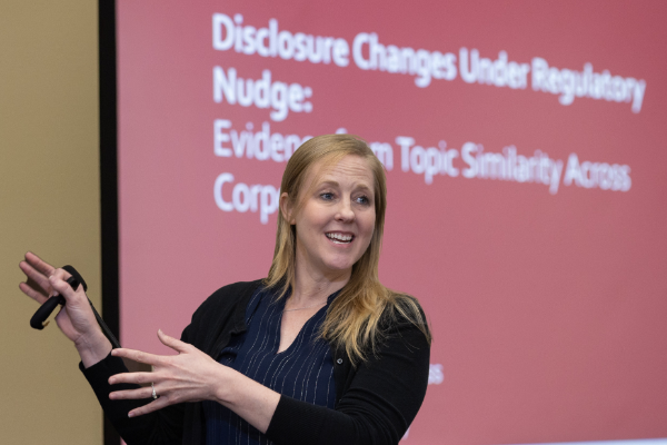 Faculty member presents in front of a screen 