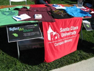 Table with Campus Ministry materials including a New Life Church banner.