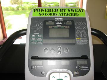 A treadmill display showing workout statistics with text POWERED BY SWEAT above it.