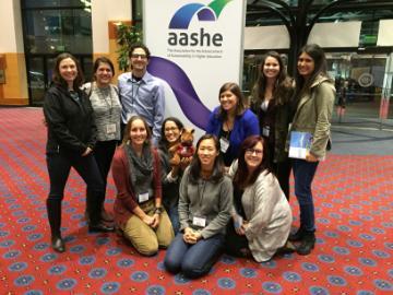 A group of people posing in front of an AASHE banner.