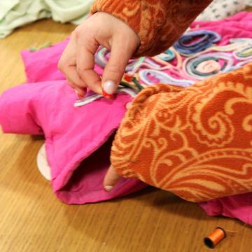 A student sewing colorful clothing