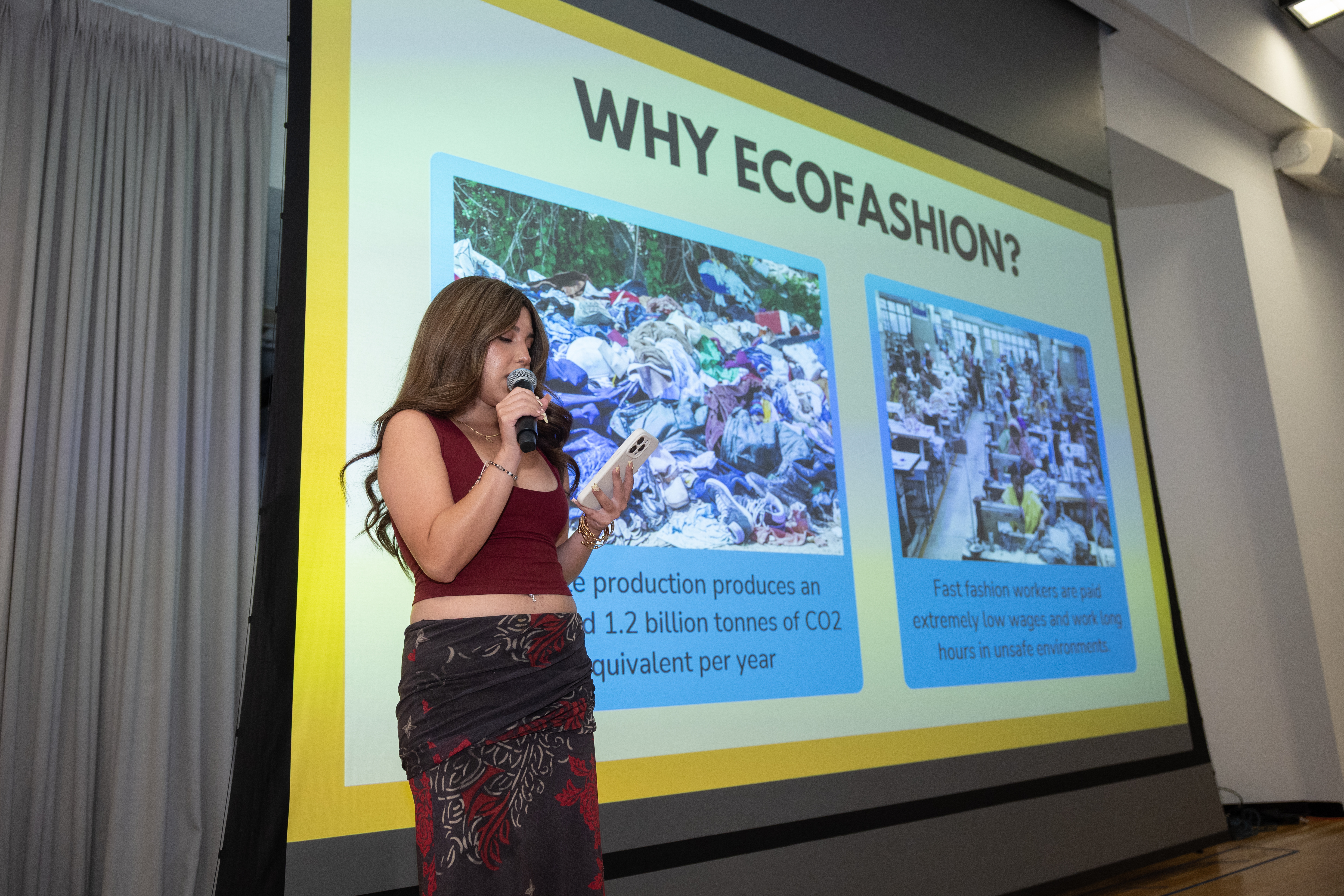 EcoFashion Show 2025: An announcer in front of a slide that explains the harmful impact of fast fashion