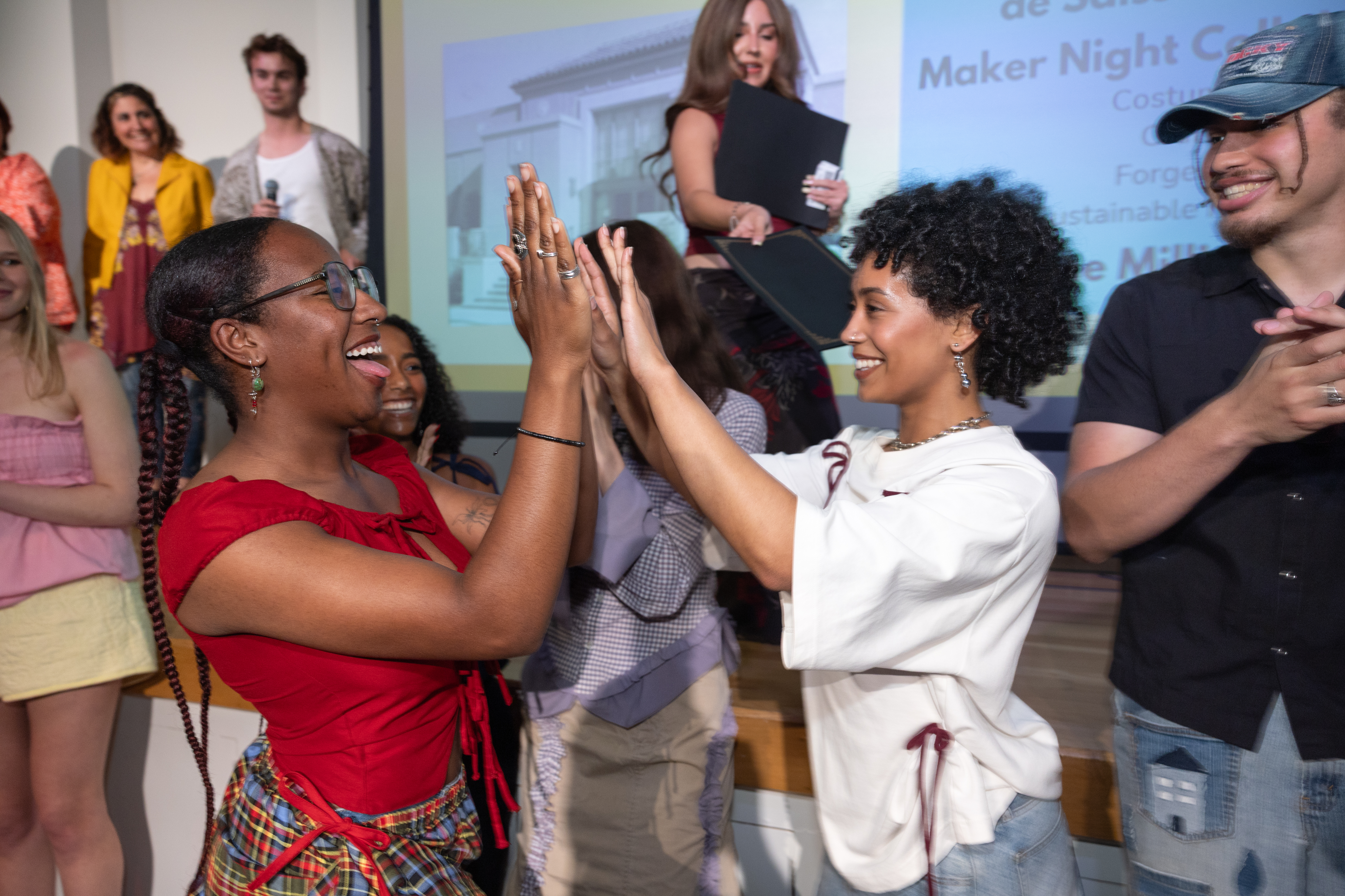 EcoFashion Show 2025: A model and designer exchange a high five