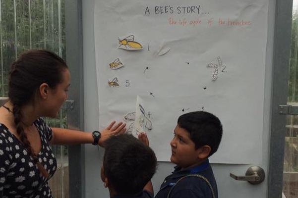 SCU student in greenhouse teaching kids about 'A Bee Story'