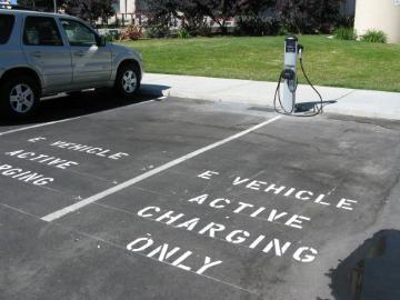 Electric vehicle charging station with designated parking space and a parked car.