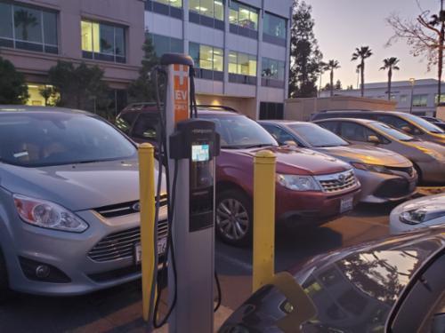 Cars parked on SCU campus hooked up to an EV charger