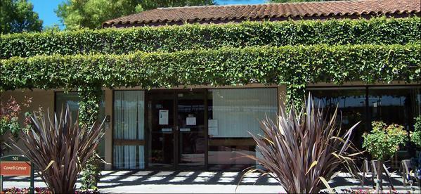 The Cowell Center entrance, covered with greenery and surrounded by plants.