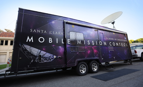 A large trailer labeled NASA's Mobile Mission Control parked on a street.