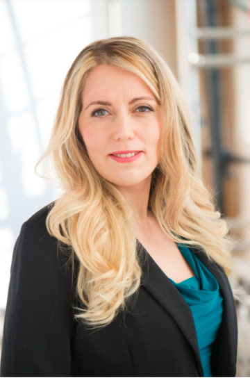 Dr. Maya Ackerman posing in a professional setting.