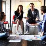 A group of five people discussing business plans in an office.