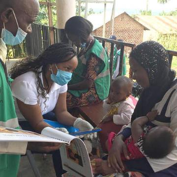 A Frugal Innovation Hub partner shares the student-created app, OmwanaThrive, with a mother in Uganda image link to story