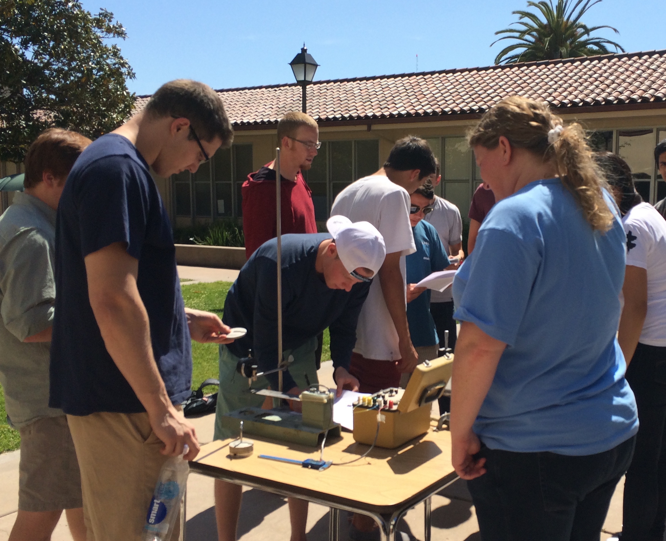 Students and professor working on an experiment in the quad.