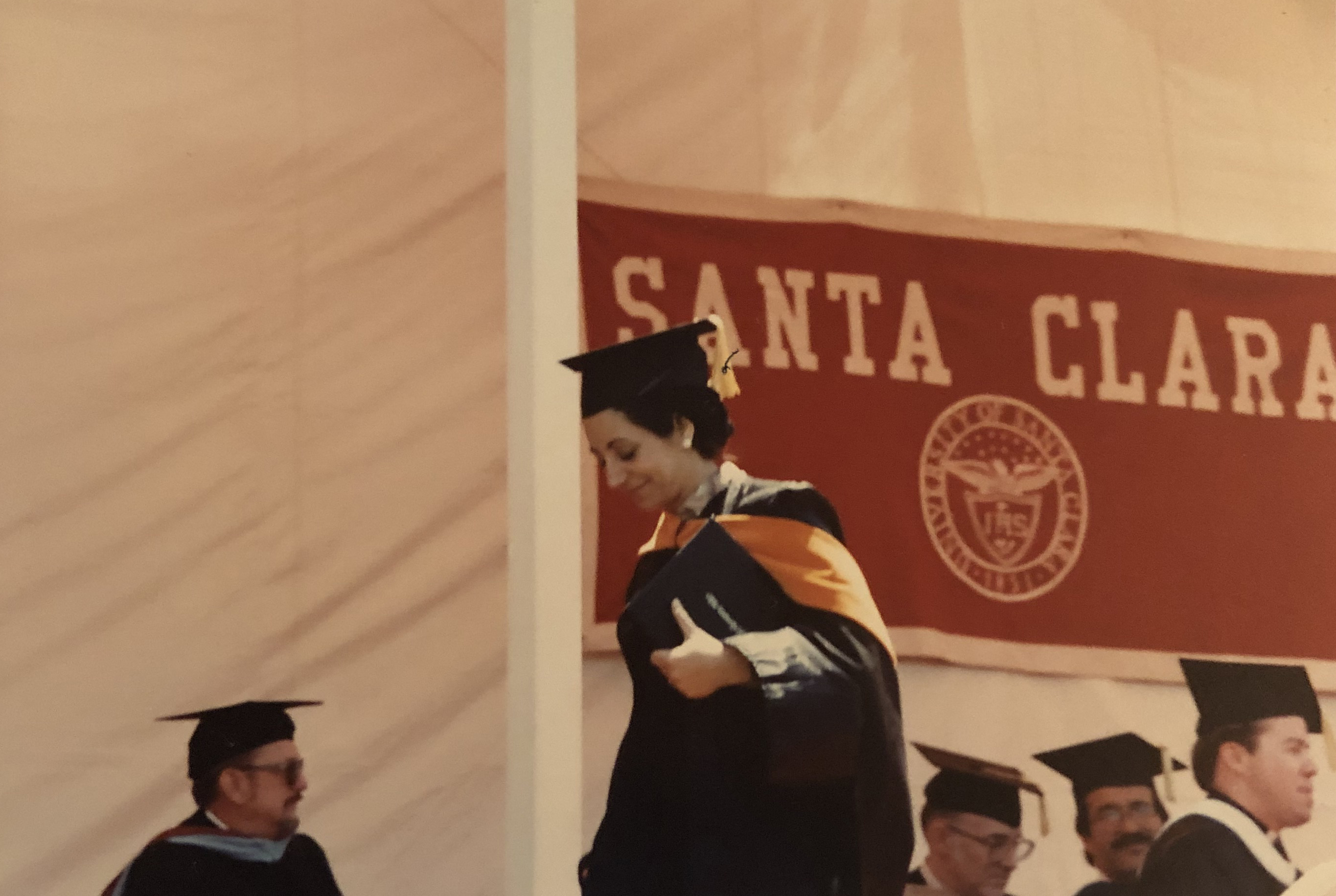Graduation ceremony with Santa Clara banner in background.