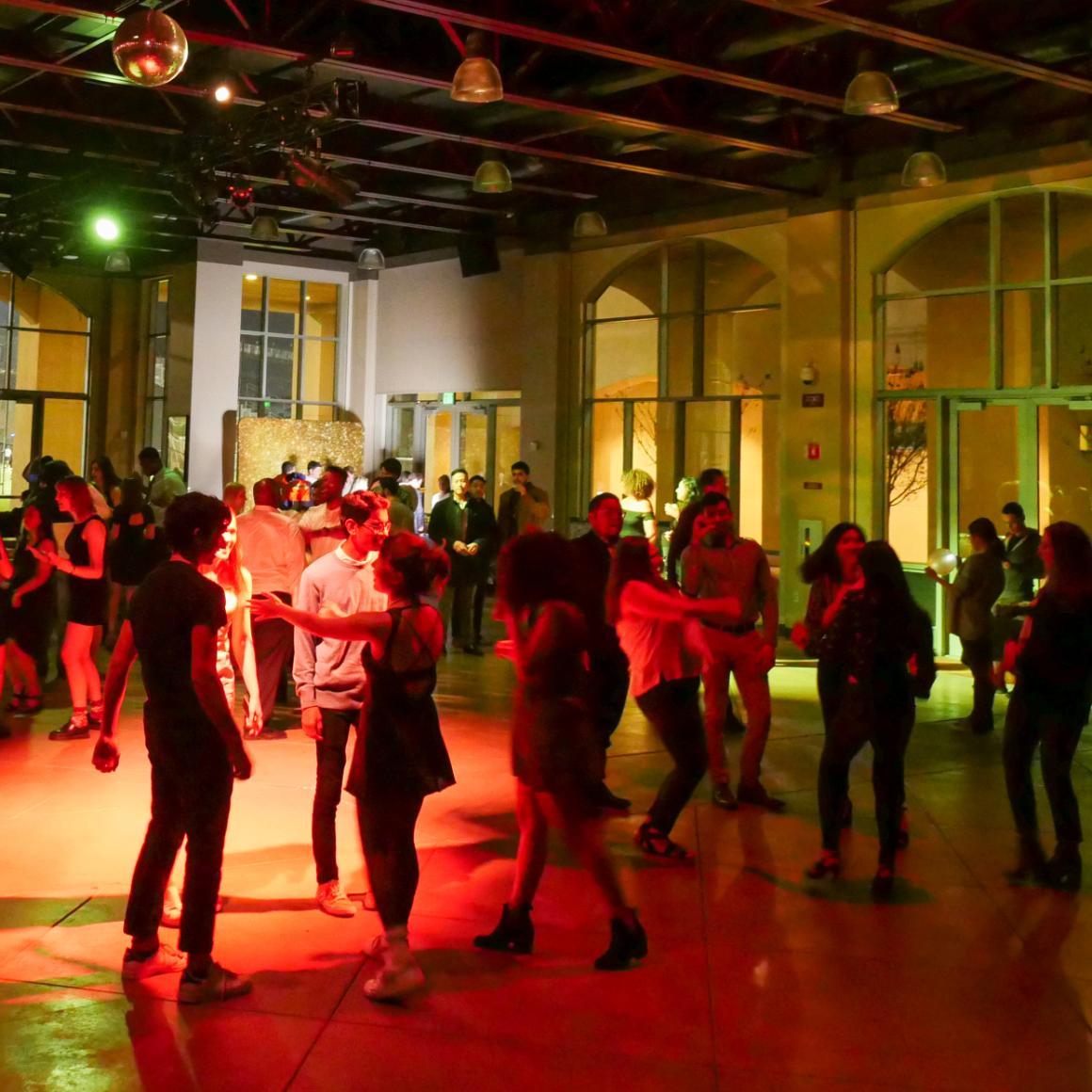 Students dance under colorful lights at the 2020 eWeek Formal
