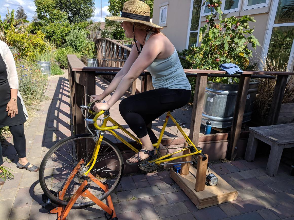 Person on stationary energy bike generating power.