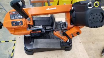 A band saw machine cutting a steel plate.